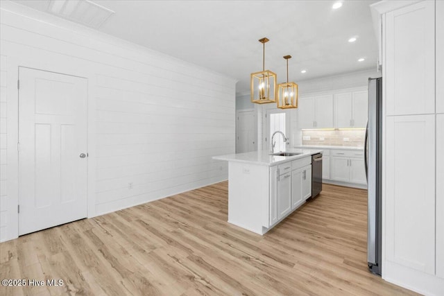 kitchen with light wood-style flooring, a sink, stainless steel appliances, white cabinets, and light countertops