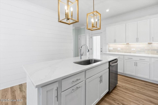 kitchen with a center island with sink, stainless steel dishwasher, a notable chandelier, white cabinetry, and a sink