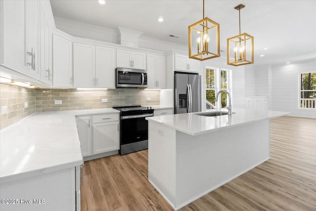 kitchen with white cabinetry, stainless steel appliances, light wood-type flooring, and a sink