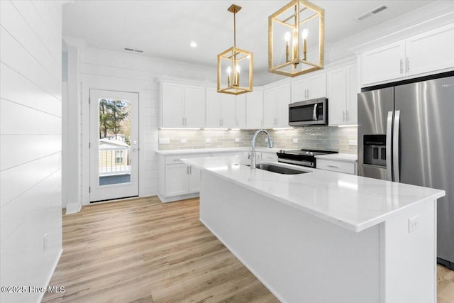 kitchen featuring white cabinets, visible vents, light wood-style flooring, appliances with stainless steel finishes, and a sink