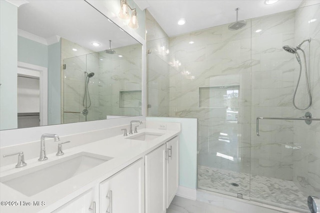 full bath featuring double vanity, marble finish floor, a marble finish shower, and a sink