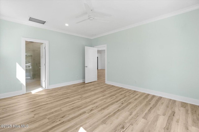 spare room with baseboards, crown molding, and light wood finished floors