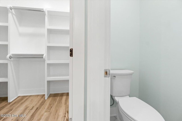 bathroom with toilet and wood finished floors