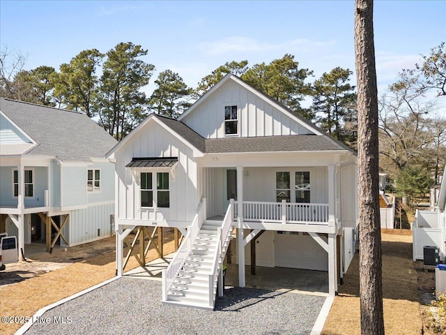 view of front of house featuring stairway, roof with shingles, board and batten siding, driveway, and covered porch