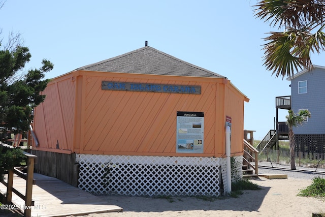 view of property exterior featuring stairs and roof with shingles