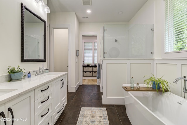 bathroom with visible vents, plenty of natural light, a stall shower, and a sink