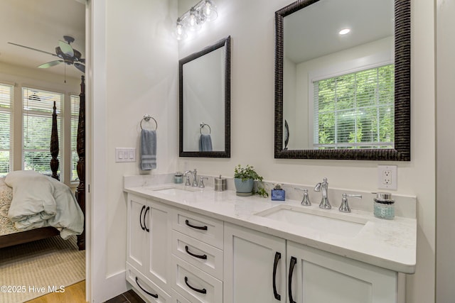 ensuite bathroom with a sink, wood finished floors, ensuite bath, and double vanity