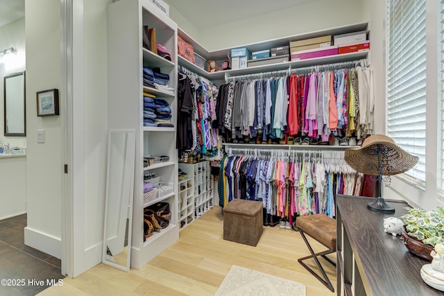 walk in closet with wood finished floors