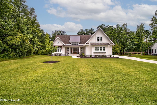 view of front of home with metal roof, board and batten siding, a front lawn, and a standing seam roof