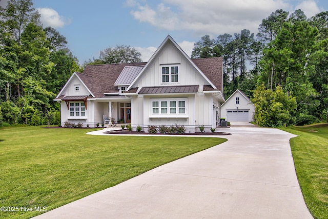 modern inspired farmhouse with a standing seam roof, board and batten siding, an outdoor structure, a front yard, and metal roof