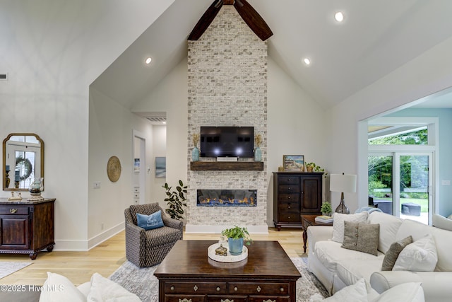 living room with high vaulted ceiling, recessed lighting, a large fireplace, light wood finished floors, and baseboards