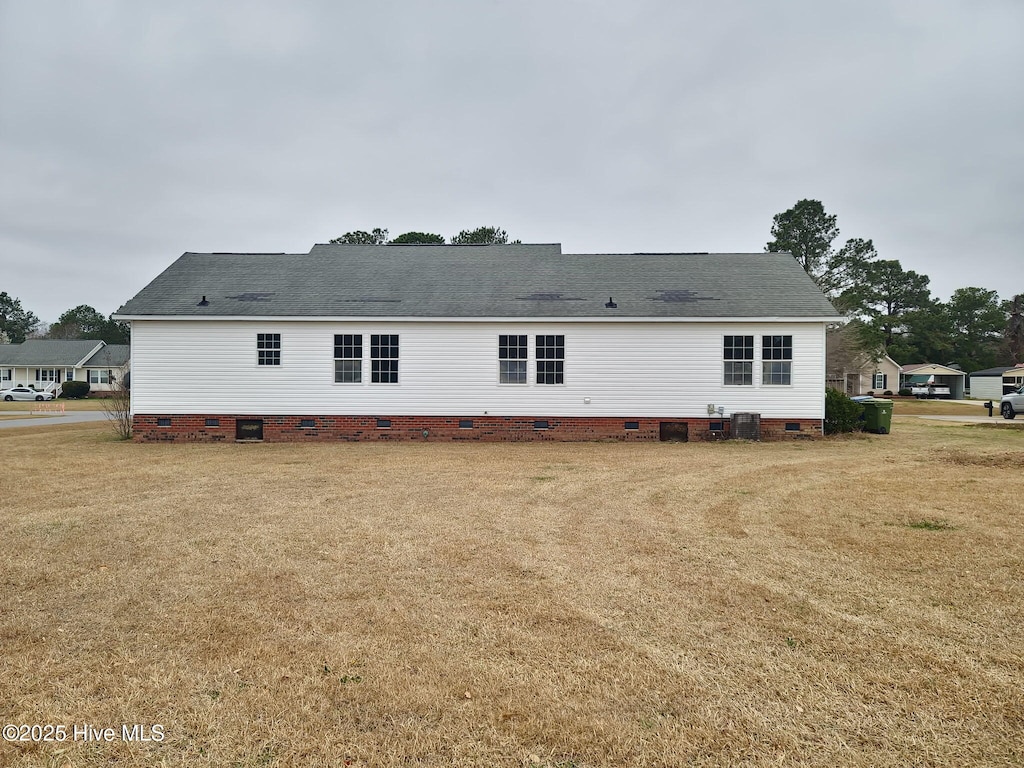 back of house featuring a yard and crawl space