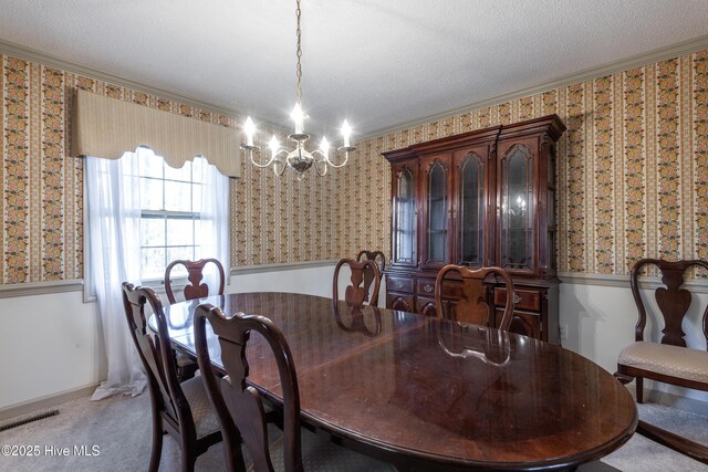 carpeted dining space featuring a textured ceiling, an inviting chandelier, crown molding, and wallpapered walls