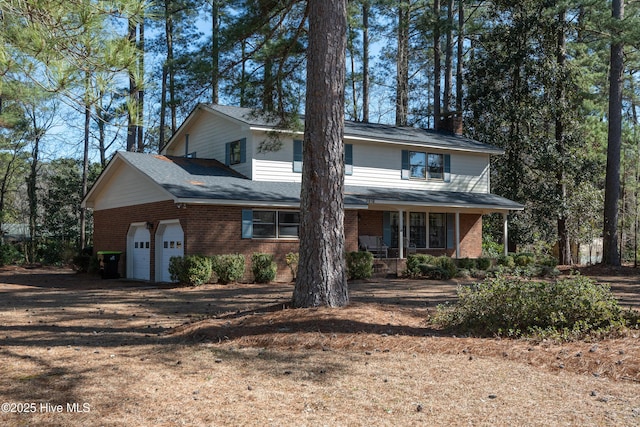 view of front of house featuring driveway, brick siding, covered porch, and an attached garage