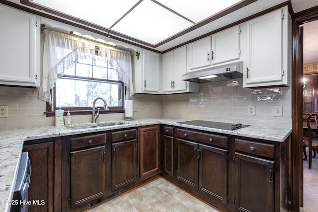 kitchen featuring visible vents, under cabinet range hood, a sink, white cabinets, and black electric stovetop