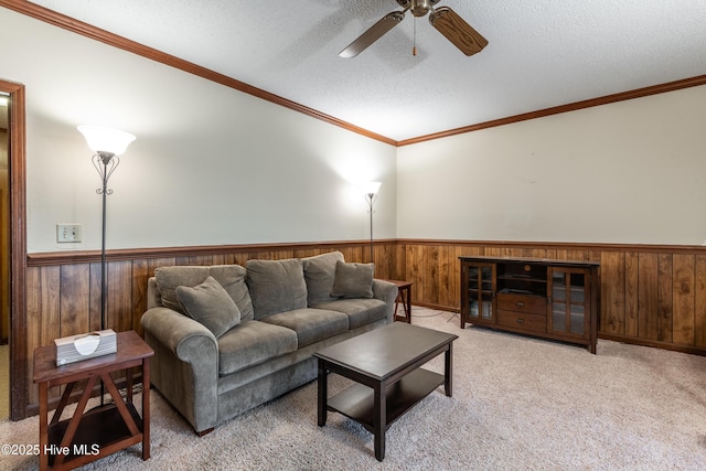 living room with a textured ceiling, wooden walls, wainscoting, and carpet