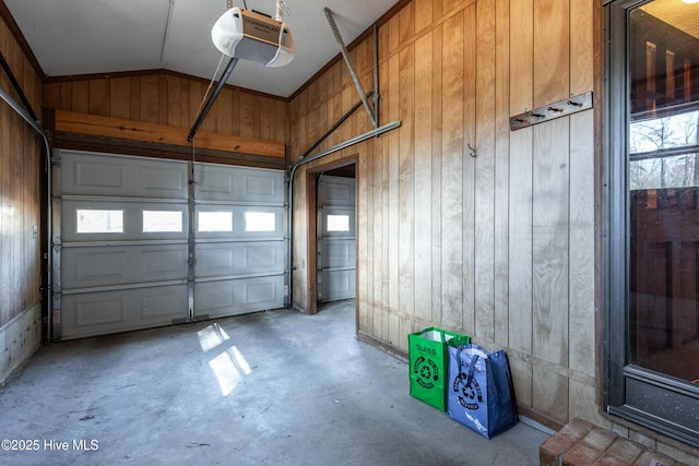 garage featuring wood walls and a garage door opener