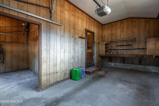 garage with wood walls and a garage door opener