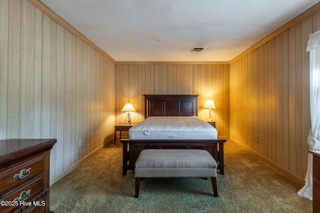 carpeted bedroom featuring baseboards, visible vents, wood walls, and a textured ceiling