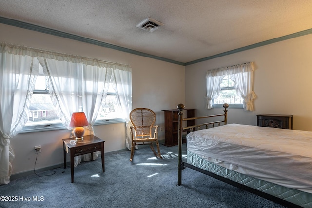 bedroom featuring visible vents, ornamental molding, a textured ceiling, carpet flooring, and baseboards