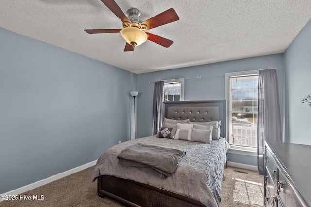 carpeted bedroom with baseboards, a textured ceiling, and a ceiling fan