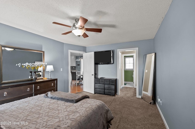 bedroom with ceiling fan, carpet, baseboards, and a textured ceiling