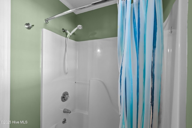 bathroom featuring crown molding and shower / bathtub combination with curtain