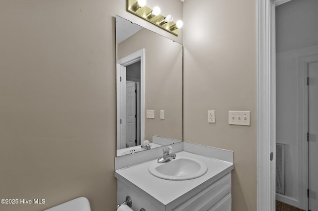 bathroom featuring visible vents, toilet, and vanity