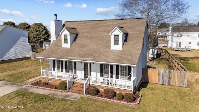 cape cod-style house with a porch, fence, roof with shingles, a front yard, and a chimney