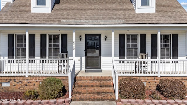 property entrance with a porch and roof with shingles