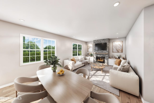 living room with recessed lighting, baseboards, light wood-type flooring, and a fireplace