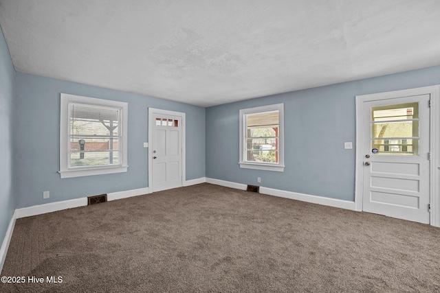 foyer featuring visible vents, baseboards, and carpet flooring