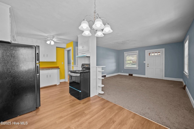 kitchen featuring baseboards, black appliances, white cabinets, under cabinet range hood, and light wood-type flooring