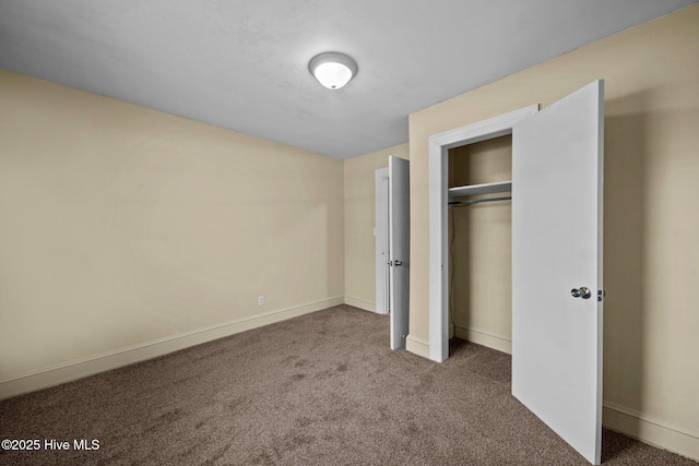 unfurnished bedroom with a closet, carpet floors, and baseboards