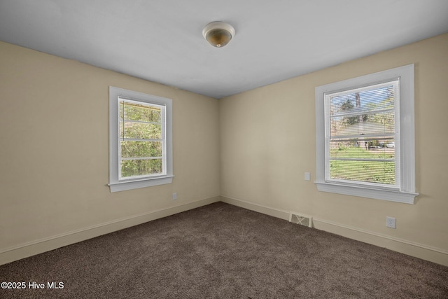 empty room with carpet flooring, baseboards, and visible vents