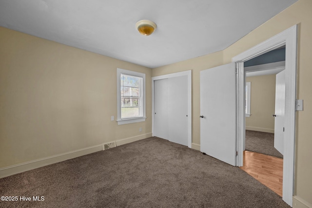 unfurnished bedroom featuring visible vents, a closet, and carpet flooring