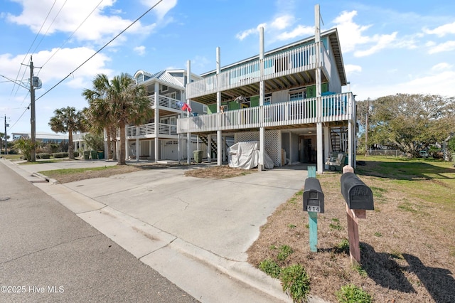 view of front of home featuring a carport, concrete driveway, and a front yard