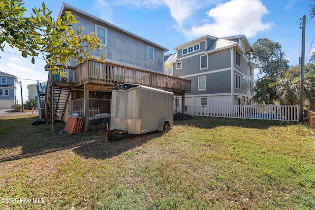 back of property with stairs, a deck, a lawn, and fence