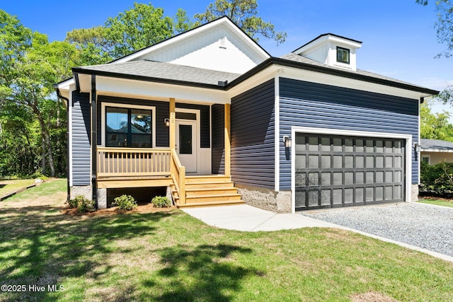 view of front of property featuring covered porch, an attached garage, gravel driveway, and a front lawn