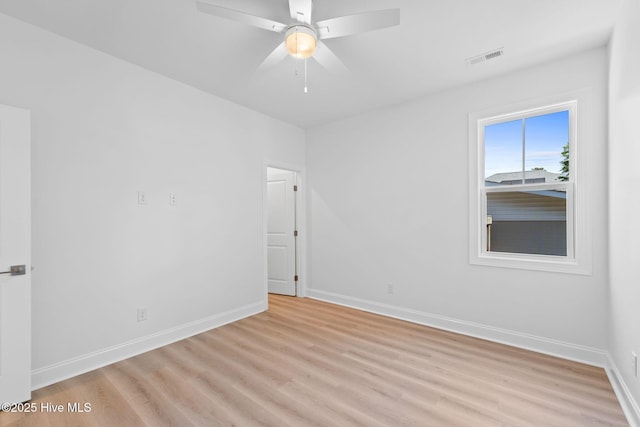 spare room featuring baseboards, a ceiling fan, light wood-style flooring, and visible vents