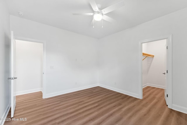 unfurnished room featuring baseboards, a ceiling fan, and wood finished floors