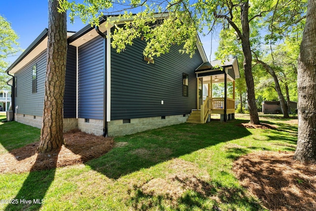 back of property featuring a lawn and crawl space