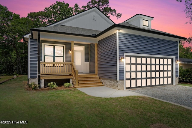 view of front of property featuring a garage, covered porch, driveway, and a front yard