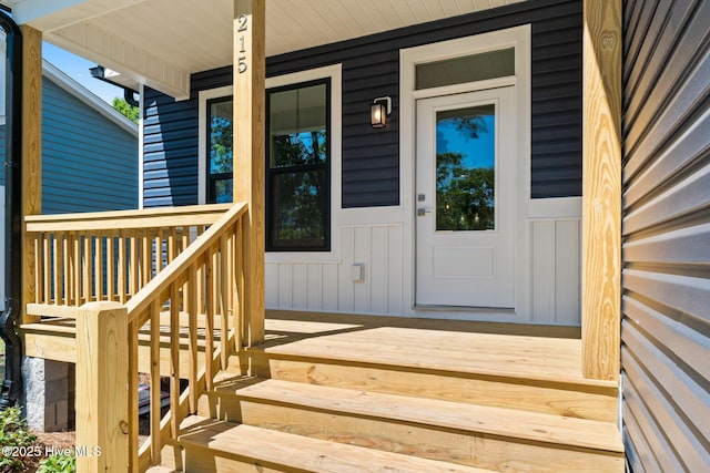 property entrance featuring board and batten siding and covered porch