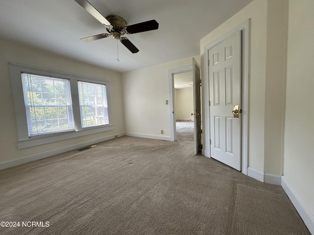 unfurnished bedroom featuring visible vents, baseboards, carpet, and a ceiling fan