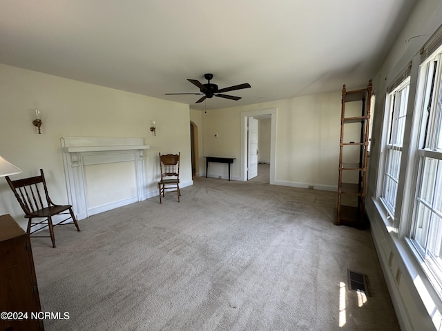 interior space with visible vents, baseboards, carpet floors, arched walkways, and a ceiling fan