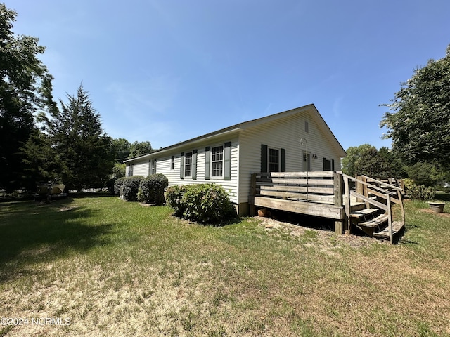 view of property exterior featuring a lawn and a deck