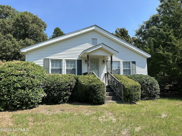 bungalow-style house featuring a front lawn