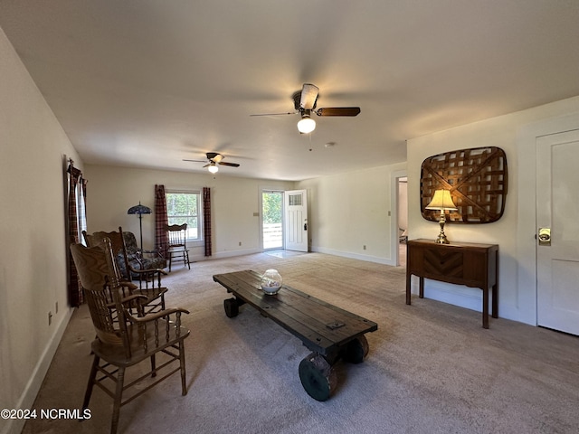 living area with baseboards, carpet, and a ceiling fan