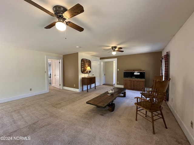 living room with baseboards, ceiling fan, and carpet flooring